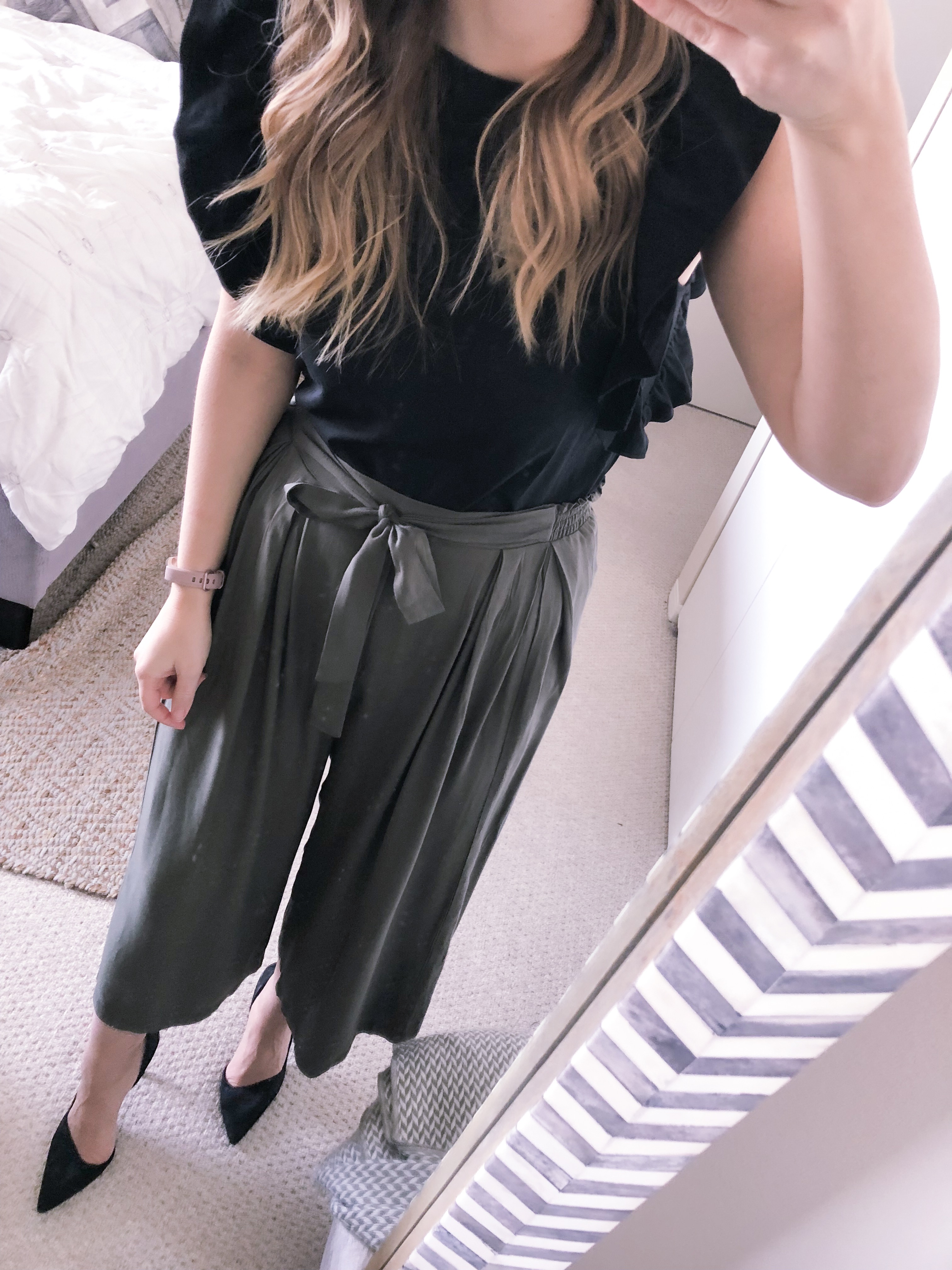 cropped olive pants and a black ruffled top